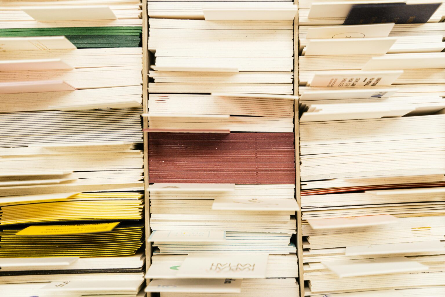 Close-up view of stacked documents in various colors organized in a file system.